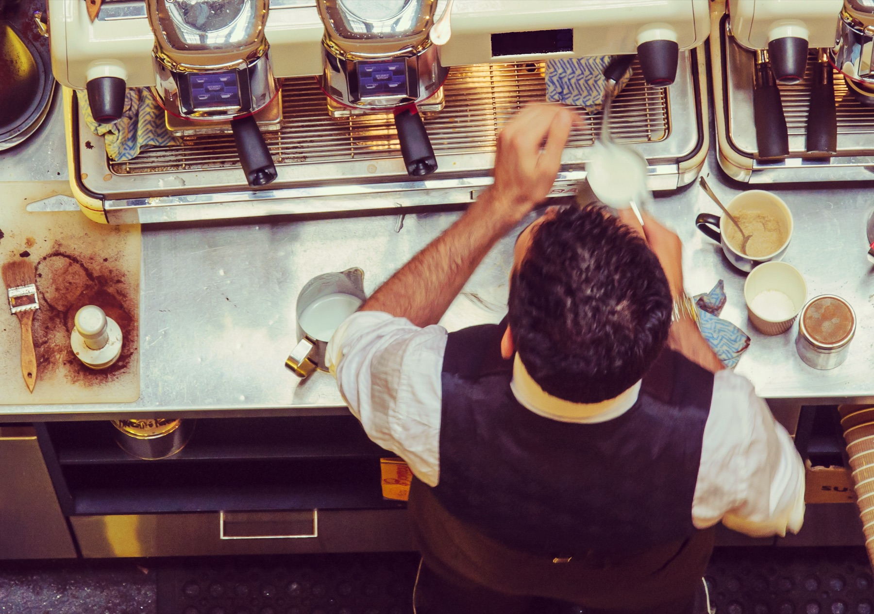 Barista vid en espressomaskin sedd uppifrån