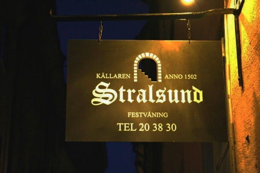 Skylt med texten K&auml;llaren Stralsund, festv&aring;ning, anno 1502
